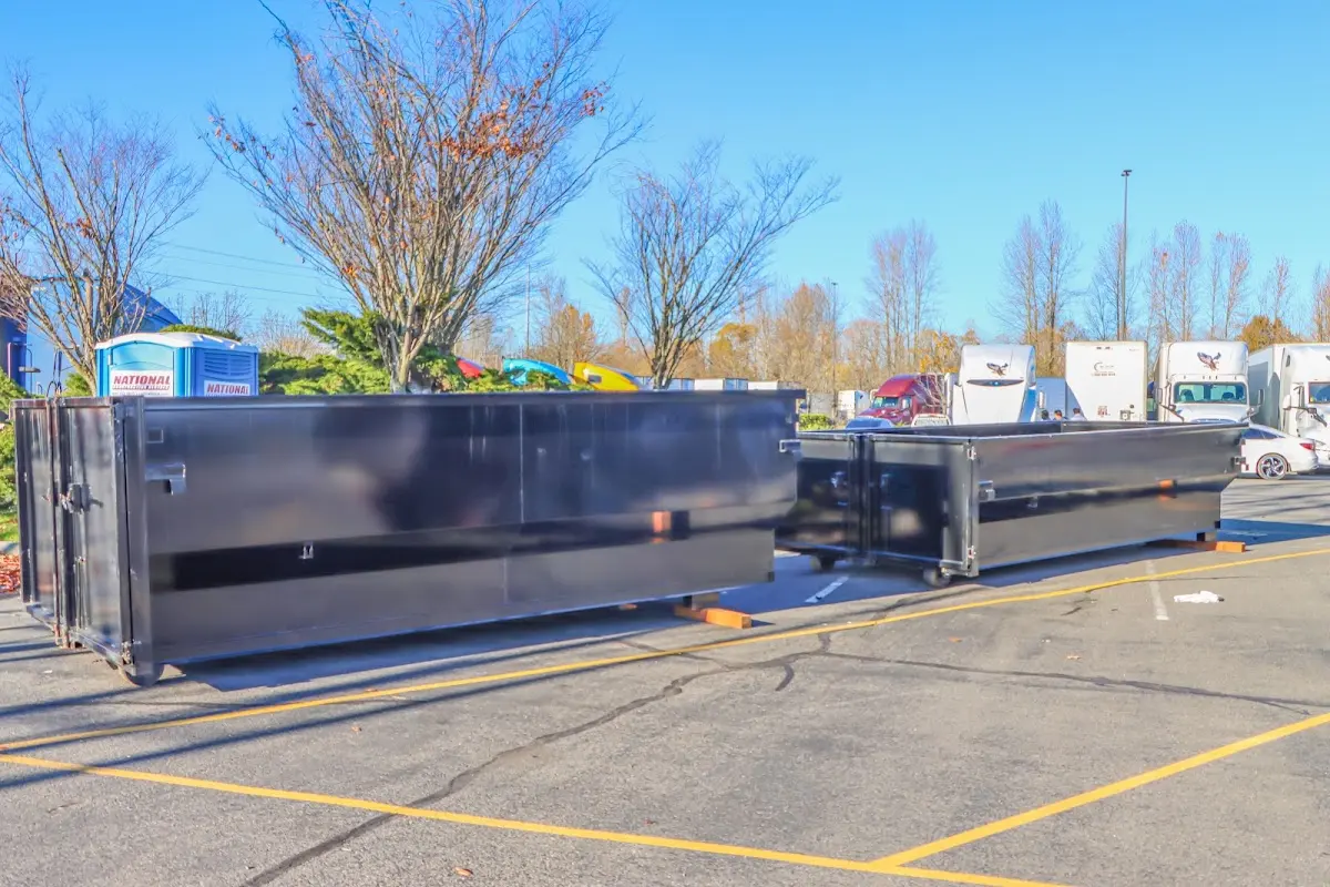 Professional dumpster rental service with roll-off container on residential driveway in Elkins